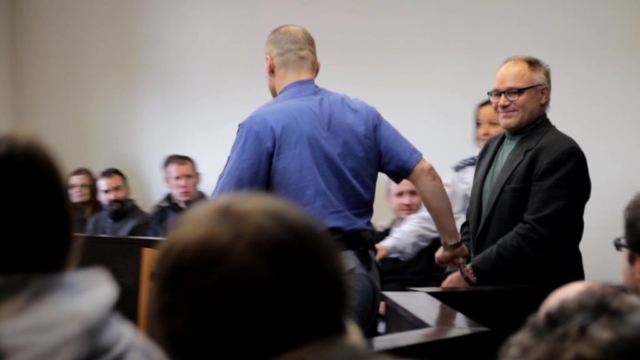 Eskorta přivádí Dušana v poutech